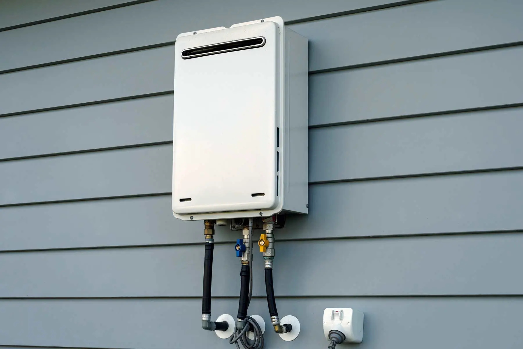 tankless water heater installed on outside wall of house